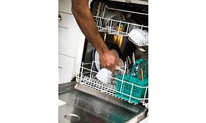 MDA-Dishwashers-Man lägger in disk i en mindre diskmaskin