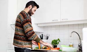 En man lagar mat i sitt kök