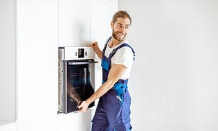 MDA-Ovens-Man tar ut en ugn ur ett skåpslucka