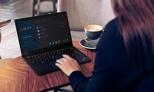 Kvinna sitter på ett kafé med Lenovo ThinkPad laptop