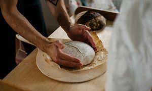 Händer som håller i nybakat bröd