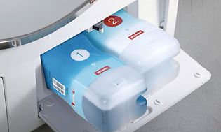 Öppen lucka för automatisk tvättmedelsdosering på en Miele tvättmaskin