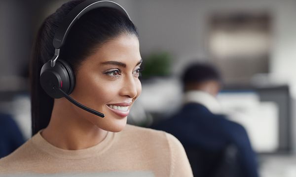 Jabra - Kvinna med svarta Evolve2 65 hörlurar på kontor