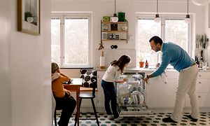 En man och en flicka tar ut disken från en integrerad diskmaskin