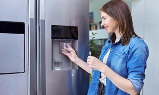 MDA-Fridges-Fridge with ice machine-Woman getting ice in glass from the fridge