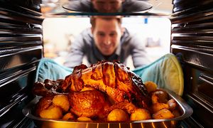MDA-Ovens-Man tar ut grillad kyckling ur ugnen