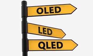 Vägvisare med gula pilar med text för OLED, QLED och LED som pekar åt olika håll.