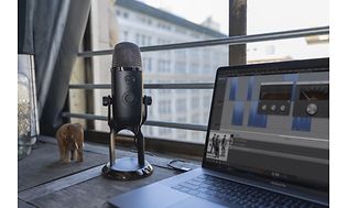 Yeti X-mikrofon på ett skrivbord med en bärbar dator