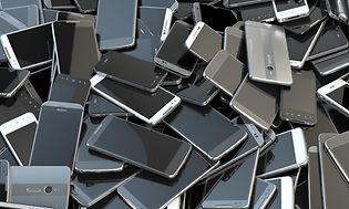 En hel hög med massor av gamla och trasiga mobiltelefoner.