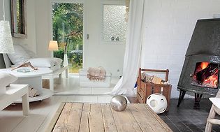 Vardagsrum i sommarstuga med en vedugn