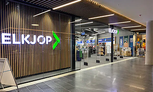 Elkjøp butiksfront med logga på väggen i ett köpcenter.
