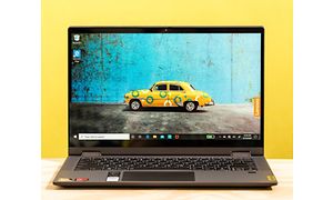 Lenovo IdeaPad Flex 5 på ett bord med gul bakgrund