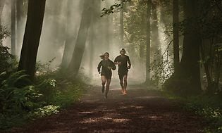 Två joggare i skogen