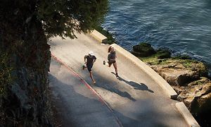 Två joggare som springer bredvid ett hav