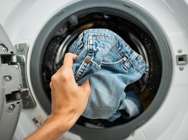MDA-Wahsing machines-Någon lägger in jeans i en tvättmaskin