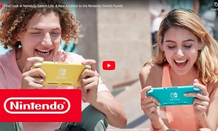 Skärmdump från video med två personer som spelar på var sin Nintendo Switch Lite-enhet, en gul och en turkos. 