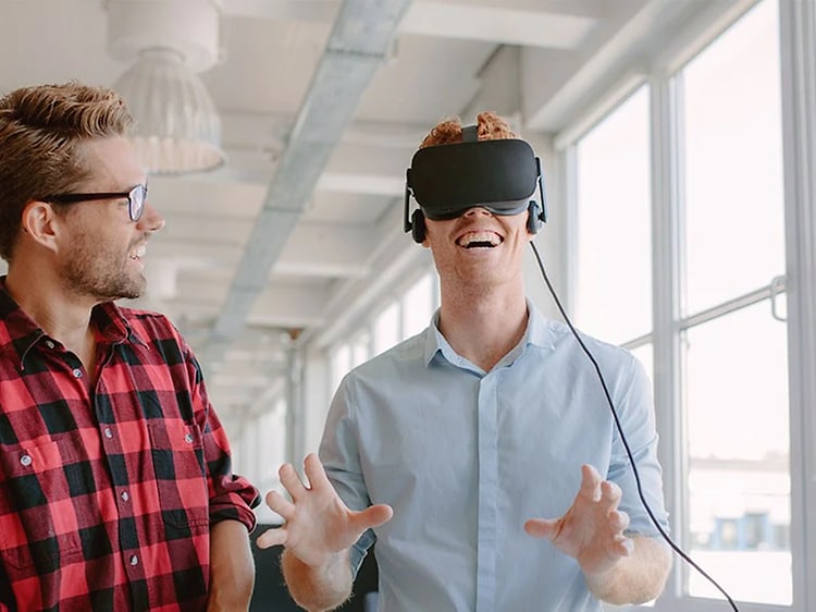 Två vänner prövar att spela med VR-glasögon 