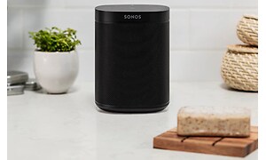 Sonos smarta svarta högtalare placerad på en vit byrå 