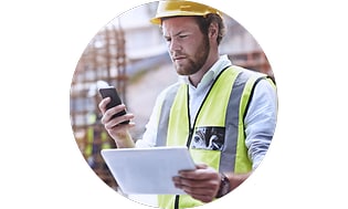 Mobilförsäkring: Byggnadsarbetare med en mobil i handen.