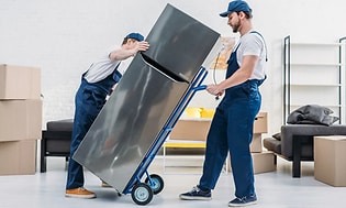 Två män levererar ett glänsande nytt kylskåp till ett hem