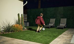 Arlo - Barn spelar fotboll i en belyst trädgård