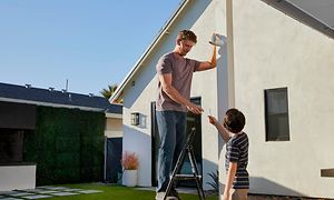 Arlo - Man monterar Arlo på ett hus