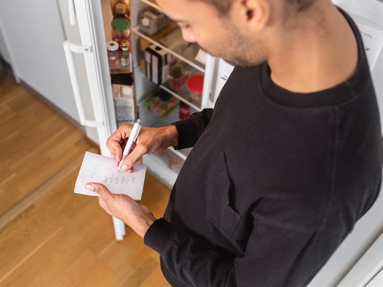MDA-Fridges-Man som antecknar framför en öppen kyl