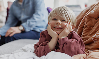 5 tips när du ska köpa ny TV: Glad unge och hans familj i bakgrunden.