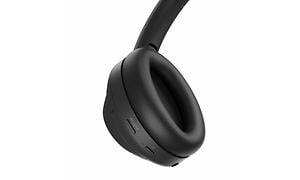 Närbild på ena öronkudden på ett par svarta on-ear hörlurar från Sony, med knappar på. 