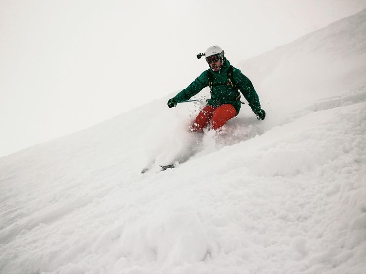 Man åker skidor nedför i en backe med en GoPro på hjälmen. 