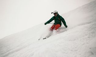 Man åker skidor nedför i en backe med en GoPro på hjälmen. 
