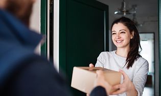 Woman recieving a package from Elkjøp