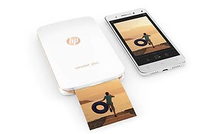 Bild på en vit mobiltelefon bredvid en vit HP Sprocket fotoskrivare.