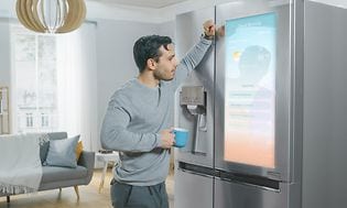 Man som ser på skärmen på ett kylskåp