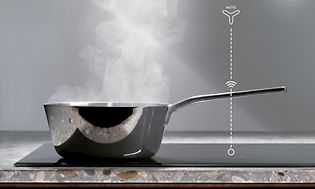 Liten kastrull med ånga ovanför på en induktionshäll
