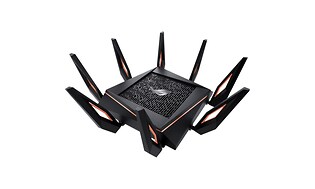 En stor svart gaming router med många antenner. Detaljer i orange färg. 