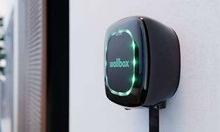 Black EV charger with green wallbox text