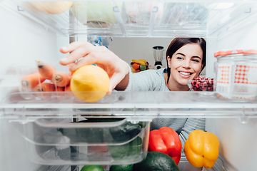 MDA-Fridges-Woman reaching for a lemon in a fridge