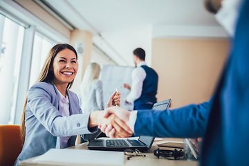 Woman shaking hands with person in blue suit