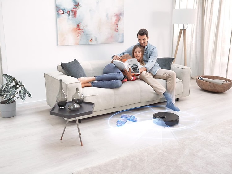 Ecovacs Deebot T9 AIVI skannar golv för rengöring medan man och kvinna kopplar av i soffan