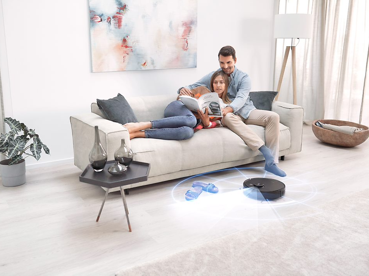 Ecovacs Deebot T9 AIVI skannar golv för rengöring medan man och kvinna kopplar av i soffan