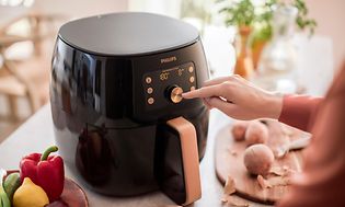 Philips airfryer och en hand som trycker på displayen