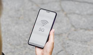 En kvinna tittar på sin smartphone med 5G