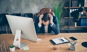 A man holding his head in frustration in his office