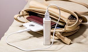 Smal powerbank som laddar en smartphone som ligger i en handväska