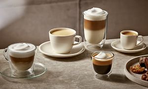 Fem sorters kaffedrycker på ett bord