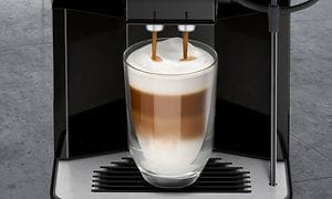 Siemens kaffemaskin som häller kaffe i ett glas med kaffe och skummad mjölk