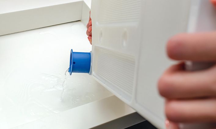 MDA-Tumble dryer-Person emptening the water from tumble dryer