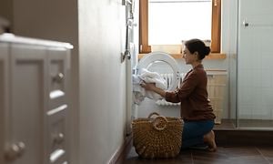 MDA-Tumble dryer- Woman putting laundry in the tumble dryer
