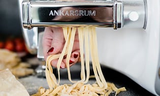 Person använder Ankarsrum köksmaskin för att göra hemmagjord pasta
